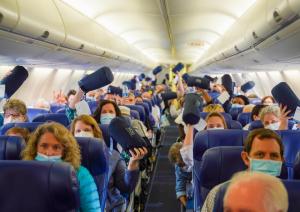 Surprised passengers display their gifts aboard their flight 